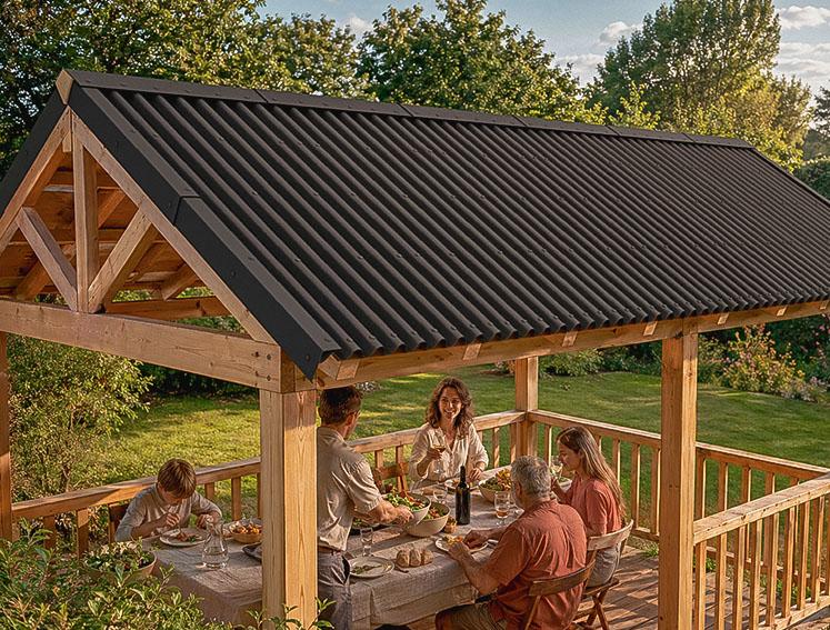 Eine Familie isst gemeinsam unter einer Pergola mit ONDULINE BASE Bitumenwellplatten als Dach.