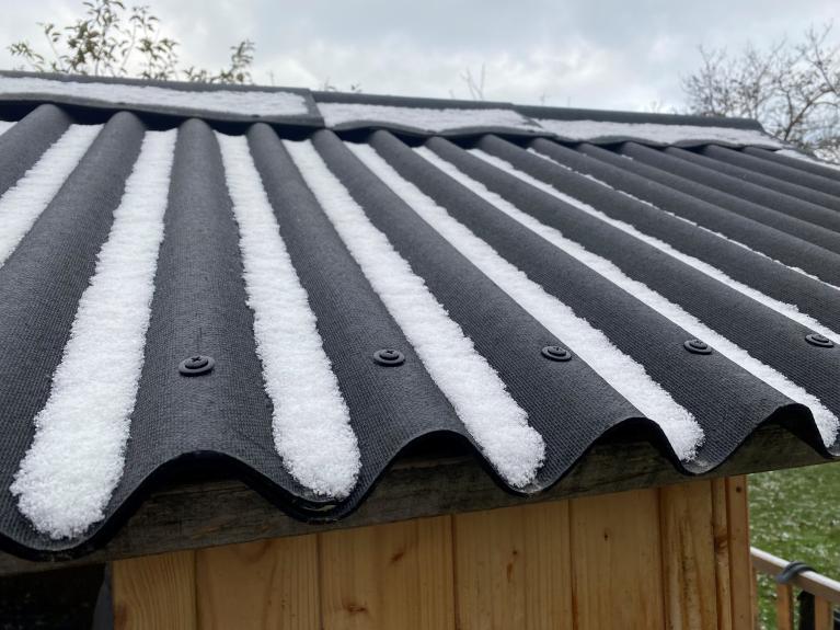 Eine verschneide Bitumenwellplatte auf einem Gartenhaus.
