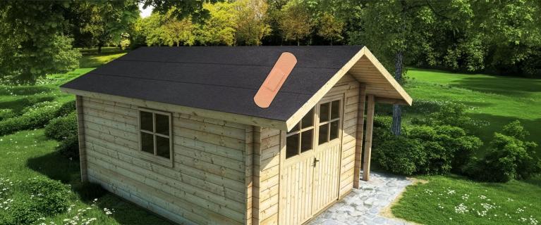 Ein Gartenhaus mit Riss im Dach und einem Pflaster darüber.