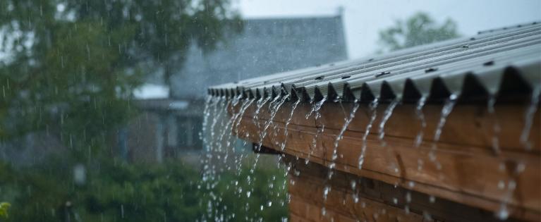 Eine Bitumenwellplatte, über die Wasser beim Regen läuft.