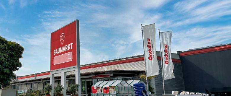 Ein Baumarkt mit Onduline-Flagge davor.
